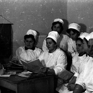 Nursing students and instructor studying together indoors.