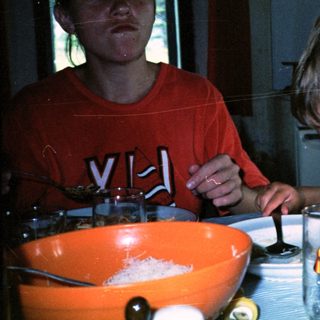 Two people making fondue together indoors.