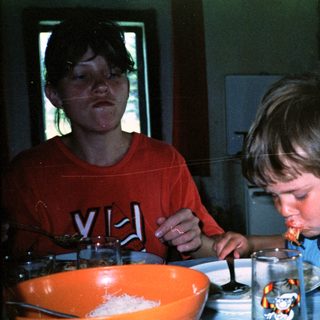 Two people making fondue together indoors.
