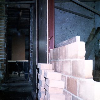 Damaged brick wall and exposed interior structure.