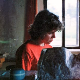Woman preparing food in dimly lit kitchen.