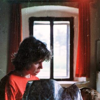 Woman preparing food in dimly lit kitchen.