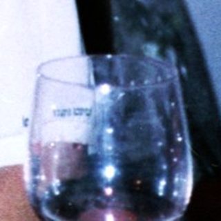 Woman in sportswear sitting indoors near glasses.