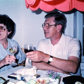 Two people enjoying drinks at a celebratory table.