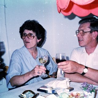 Two people enjoying drinks at a celebratory table.