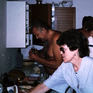People preparing food in a rustic kitchen.