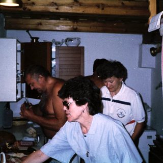 People preparing food in a rustic kitchen.