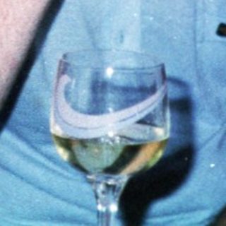 Two men sitting indoors, drinking and conversing.