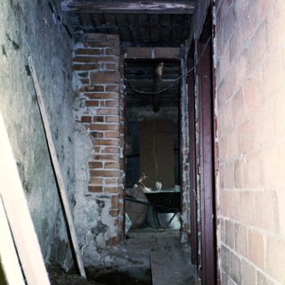 Abandoned basement with exposed brick and debris.