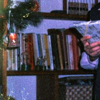 Young girl reading book in dimly lit room.