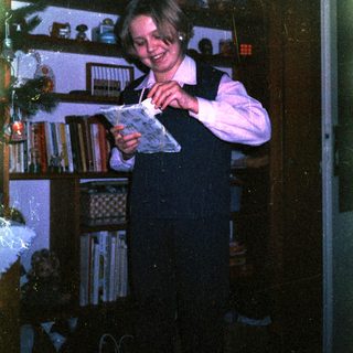 Young girl reading book in dimly lit room.