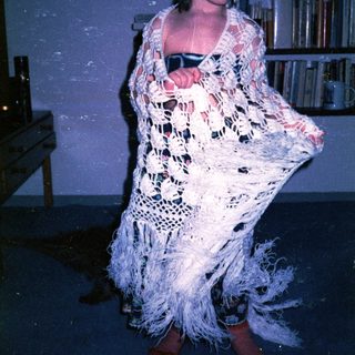 Person in elaborate crochet flamenco dress dancing indoors.