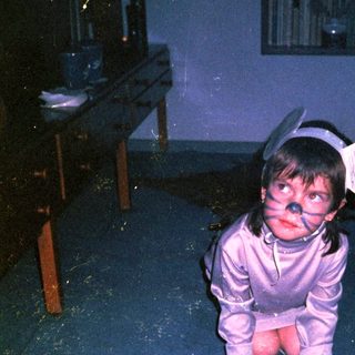Child in costume crawling on floor.