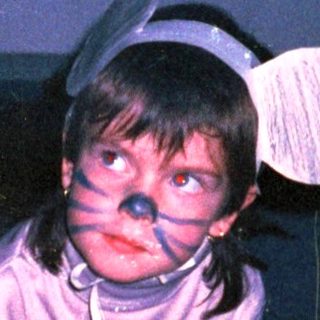Child in costume crawling on floor.