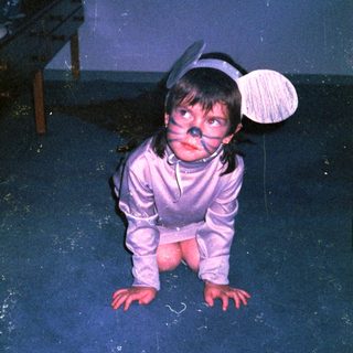 Child in costume crawling on floor.