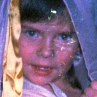 Child dressed as a bride in vintage wedding attire.