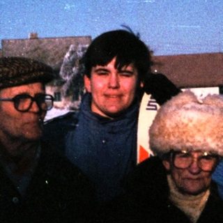 Four people posing together on snow-covered ground.