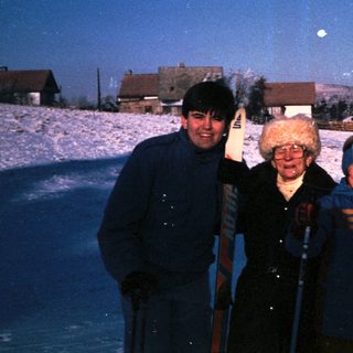 Three people posing happily in snowy landscape.