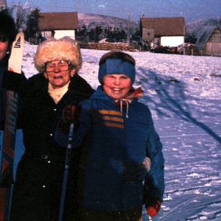 Three people posing happily in snowy landscape.