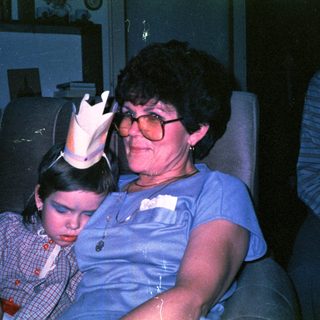 A woman and child wearing party hats indoors.