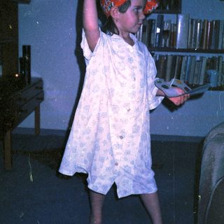 Child in pirate hat playing sword game indoors.