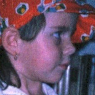 Child in pirate hat playing sword game indoors.