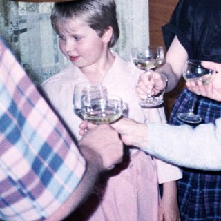 Family gathering with wine glasses indoors.