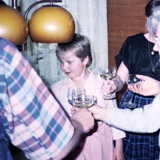 Family gathering with wine glasses indoors.