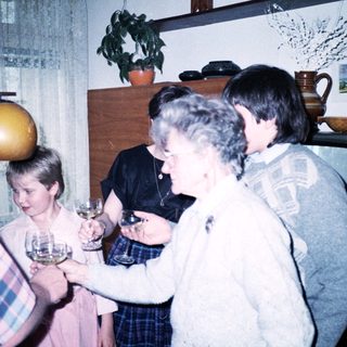 Family gathering with wine glasses indoors.