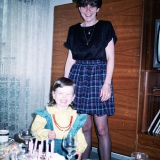 Two women celebrating a birthday with cake.