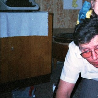 Joyful man carrying smiling child indoors.