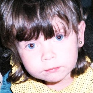 Young child in costume crawling on floor.