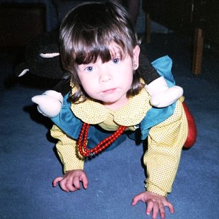 Young child in costume crawling on floor.