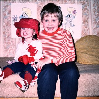 Two children posing happily with Smurf-themed decorations.