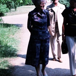 Four women walking together in a park.