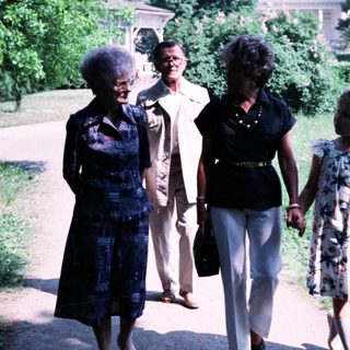 Four women walking together in a park.
