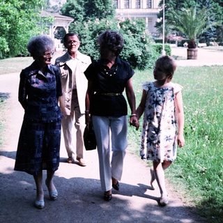 Four women walking together in a park.