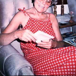Woman reading mail in red dress.
