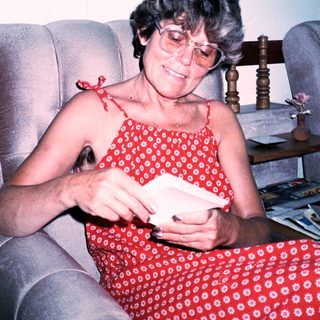 Woman reading mail in red dress.