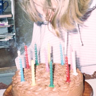 Dog blowing out birthday candles on cake.