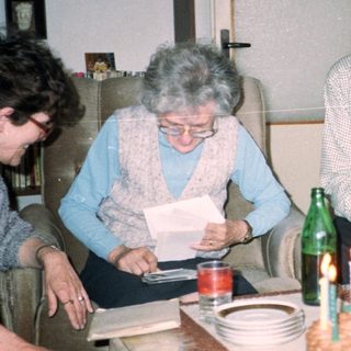 Family celebrating birthday with cake and drinks.