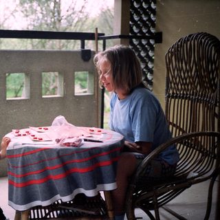 Two people playing cards outdoors on patio.