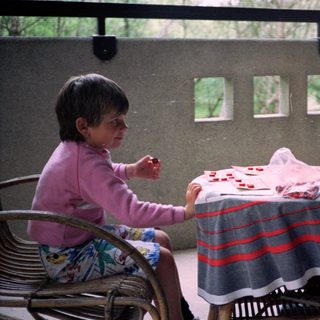 Two people playing cards outdoors on patio.