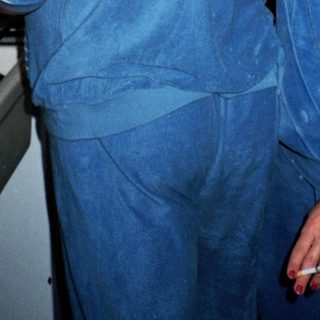 Two people in blue hospital scrubs discussing inside a medical facility.