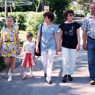 Family walking together outdoors in a park.