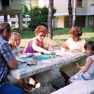 Family enjoying outdoor picnic or meal together.