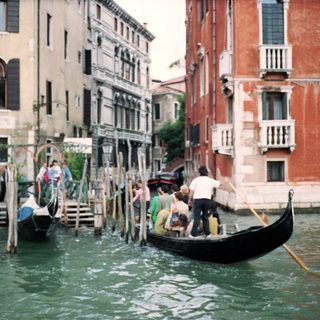 Traditional gondolas navigating Venice canals with rowers.