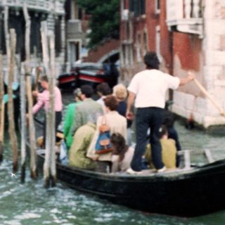 Traditional gondolas navigating Venice canals with rowers.