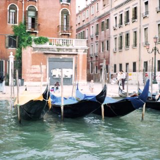 Venetian canal with docked gondolas and historic buildings.