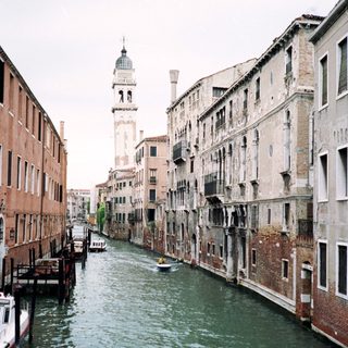 Classic Venetian canal with historic buildings and bell tower.
